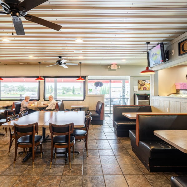 Two elderly customers dine at a table in the Pizagel's Pizza & Bakery restaurant.